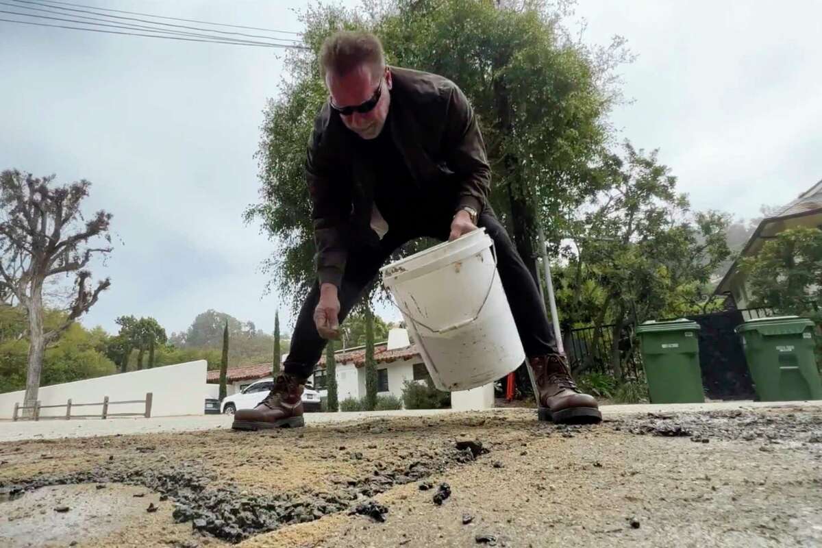 Schwarzenegger, com as próprias mãos, conserta buraco da rua onde reside